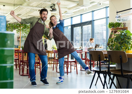 Man and woman waiters celebrating at restaurant 127691084
