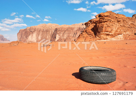 Old tire discarded in Wadi Rum desert, nature pollution concept Old tire discarded in Wadi Rum desert, nature pollution concept 127691179