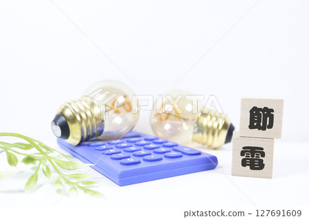 Image of saving electricity: Light bulb, calculator and wooden block 127691609