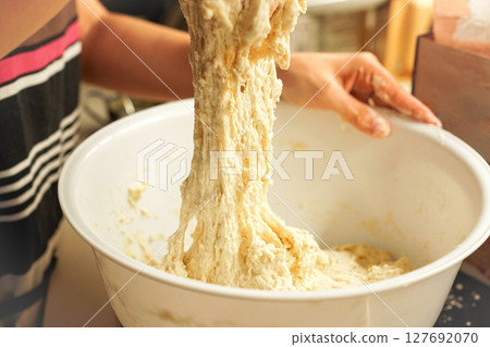 一位年輕女子正在揉麵團做麵包。正在製作麵包。 127692070