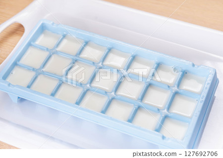 Freeze milk in ice cube trays Freeze milk in ice cube trays 127692706