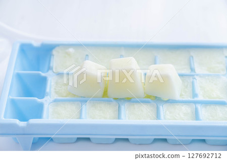Frozen milk in ice cube trays Frozen milk in ice cube trays 127692712