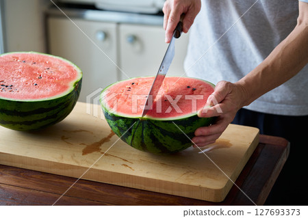 man cutting watermelon man cutting watermelon 127693373