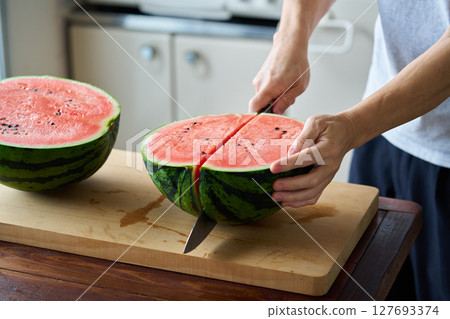 man cutting watermelon man cutting watermelon 127693374