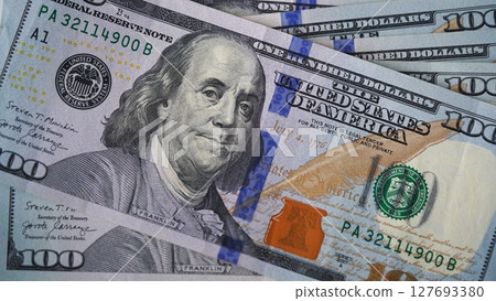 Pile of US 100 dollar banknotes spread across the surface. Concept of wealth, financial success, cash savings, banking, investment, inflation, and the global value of the US currency. 127693380