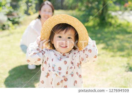 Parent and child playing in the park 127694509