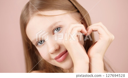 A smiliing girl forms a heart shape hands. Self care ads. Face. Love Support. Caring Positive. Gen Alpha. Natural beauty. Glowing skin. Youthful confidence. Individuality. Real beauty. Self-expression A smiliing girl forms a heart shape hands. Self care ads. Face. Love Support. Caring Positive. Gen Alpha. Natural beauty. Glowing skin. Youthful confidence. Individuality. Real beauty. Self-expression 127694528