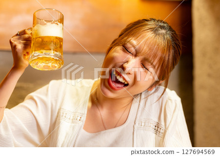 Woman drinking beer 127694569