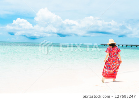 熱帶海灘度假村中身穿連身裙的年輕女子 127695247
