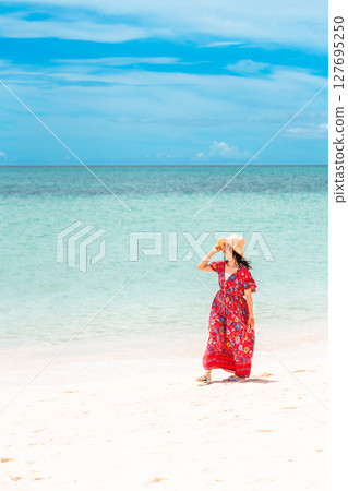 熱帶海灘度假村中身穿連身裙的年輕女子 127695250