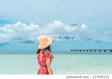 熱帶海灘度假村中身穿連身裙的年輕女子 127695252