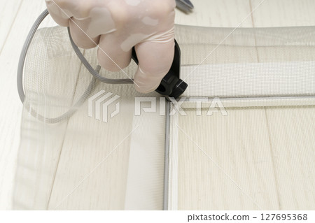 更換紗門：剪開紗門並用滾筒將繩子推入框架。 127695368