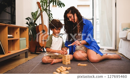 Mother and son playing wooden block game at home Mother and son playing wooden block game at home 127695460