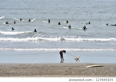 片瀨西濱海灘擠滿了等待海浪的衝浪者，還有一位女士在遛狗 127695835