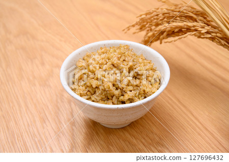 木桌背景上碗裡的糙米和米穗 木桌背景上碗裡的糙米和米穗 127696432