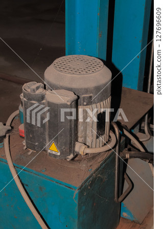 Detail view of industrial hydraulic power unit with electric motor and controls Detail view of industrial hydraulic power unit with electric motor and controls 127696609
