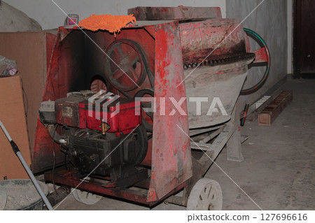 Old Red Cement Mixer Machine Used in Construction Work Area 127696616