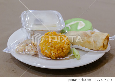 Assortment of delicious traditional Indonesian snacks presented on a white plate Assortment of delicious traditional Indonesian snacks presented on a white plate 127696723