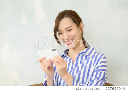 A woman watching video content on her smartphone A woman watching video content on her smartphone 127696944