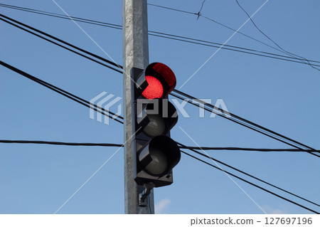 Red Traffic Light Against Blue Sky Red Traffic Light Against Blue Sky 127697196