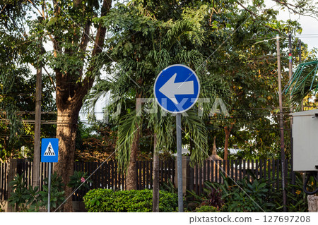Blue Left Turn Traffic Sign in Urban Setting 127697208