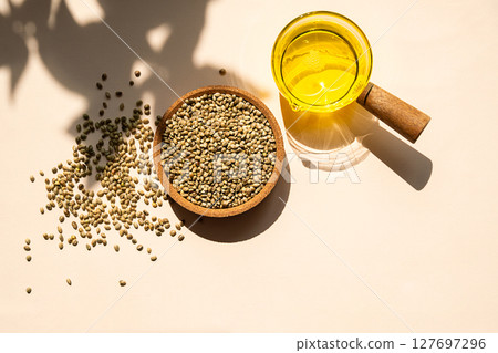 Hemp Seeds in Bowl and Hemp Seed Oil in a Clear Glass Pot. Cannabis Natural Product for Healthy Diet. Hemp Seeds in Bowl and Hemp Seed Oil in a Clear Glass Pot. Cannabis Natural Product for Healthy Diet. 127697296