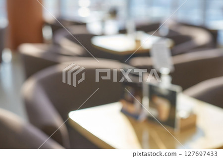 Blurred empty coffee shop interior with soft light and cozy ambiance in morning Blurred empty coffee shop interior with soft light and cozy ambiance in morning 127697433