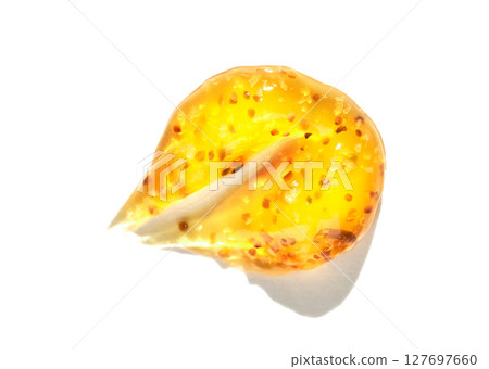 Close up of single yellow tomato seed with gelatinous coating on white 127697660