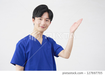 Doctor, nurse, dentist, caregiver, man pointing to the right with palm, white background Doctor, nurse, dentist, caregiver, man pointing to the right with palm, white background 127697705