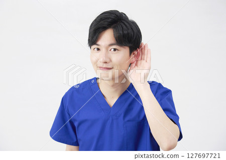 Doctor, nurse, dentist, caregiver, man holding hand to ear, white background Doctor, nurse, dentist, caregiver, man holding hand to ear, white background 127697721