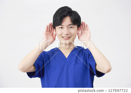 Doctor, nurse, dentist, caregiver, man holding hand to ear, white background Doctor, nurse, dentist, caregiver, man holding hand to ear, white background 127697722