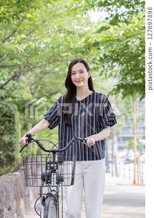 推擠自行車的一位小姐 推擠自行車的一位小姐 127697898