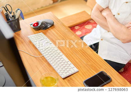 A man in his 50s staring at a computer screen and thinking 127698063