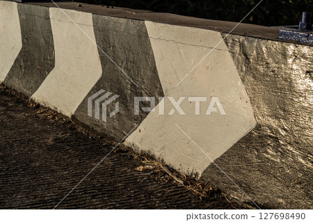 Textured Roadside Wall with Directional Arrows 127698490