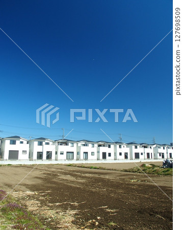 A group of prefabricated houses and fallow fields in early spring 127698509