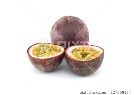 Fresh passion fruits, Passiflora edulis, presenting a whole fruit and two halves showing the pulp and seeds 127699134