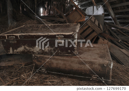 Two old, rusty, dusty and dirty suitcases lying in attic on hay straws Two old, rusty, dusty and dirty suitcases lying in attic on hay straws 127699170