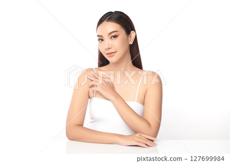 A beautiful young Asian woman with clean, fresh skin against a white background. Skincare, facial treatment, cosmetology, beauty, and spa. An elegant portrait of an Asian woman. 127699984
