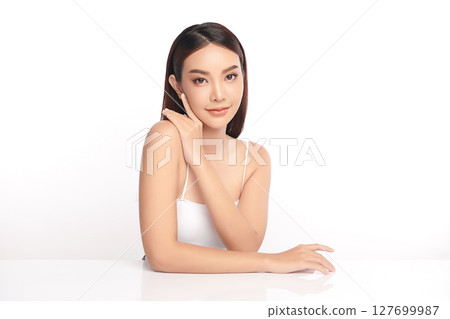 A beautiful young Asian woman with clean, fresh skin against a white background. Skincare, facial treatment, cosmetology, beauty, and spa. An elegant portrait of an Asian woman. A beautiful young Asian woman with clean, fresh skin against a white background. Skincare, facial treatment, cosmetology, beauty, and spa. An elegant portrait of an Asian woman. 127699987