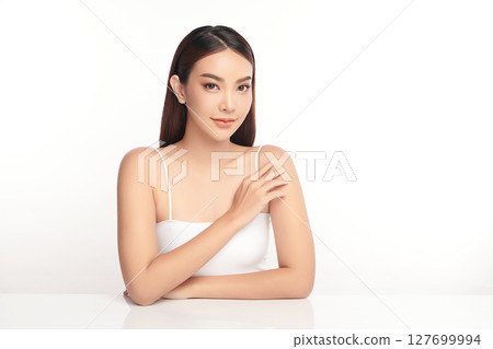 A beautiful young Asian woman with clean, fresh skin against a white background. Skincare, facial treatment, cosmetology, beauty, and spa. An elegant portrait of an Asian woman. 127699994