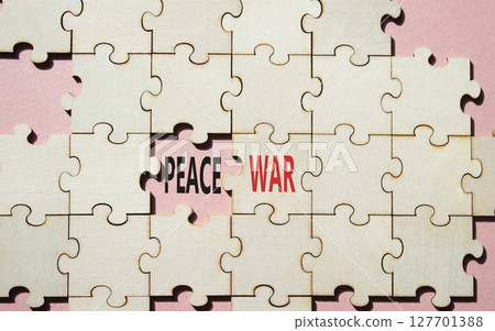 War or Peace symbol. Concept word War or Peace on wooden puzzle. Beautiful pink background. Business and War or Peace concept. Copy space War or Peace symbol. Concept word War or Peace on wooden puzzle. Beautiful pink background. Business and War or Peace concept. Copy space 127701388