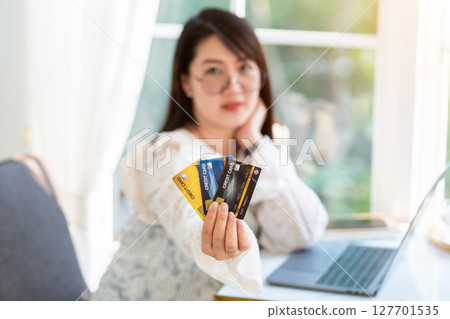 freelance people business female casual Abstract blur with focus on show holding a credit card working with laptop computer in coffee shop like the background,for online shopping and payment 127701535