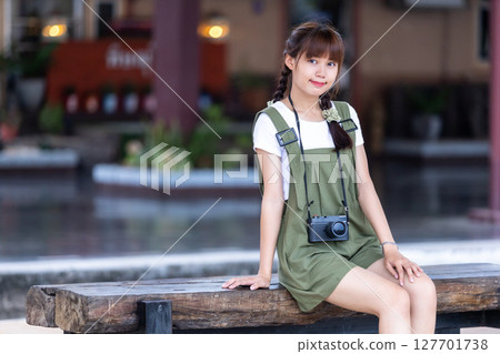 Portrait Young asian woman smiling tourist Traveler girl walking and with a holding the camera waits train travel journey is taken in railway platform Thailand, summer relax vacation Concept. Portrait Young asian woman smiling tourist Traveler girl walking and with a holding the camera waits train travel journey is taken in railway platform Thailand, summer relax vacation Concept. 127701738