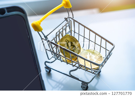 Close-up of Golden bitcoins or cryptocurrency coin or symbols in shopping cart and tablet in white table. Future currency concept. 127701770