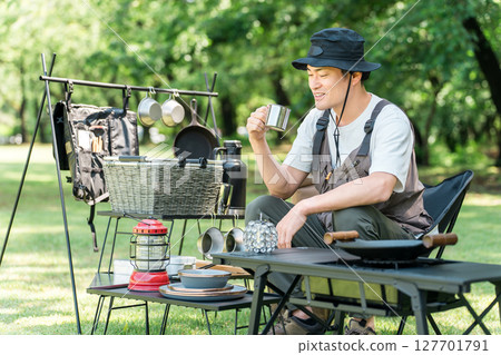 一名中年男性露營者獨自在露營地的草地上露營 一名中年男性露營者獨自在露營地的草地上露營 127701791
