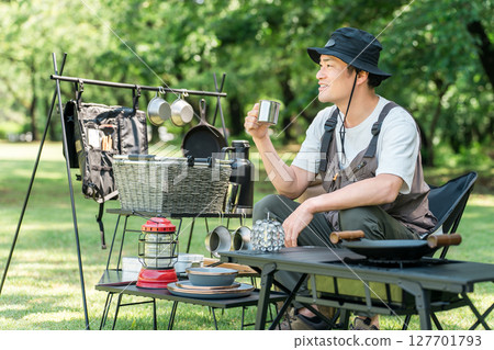 一名中年男性露營者獨自在露營地的草地上露營 127701793