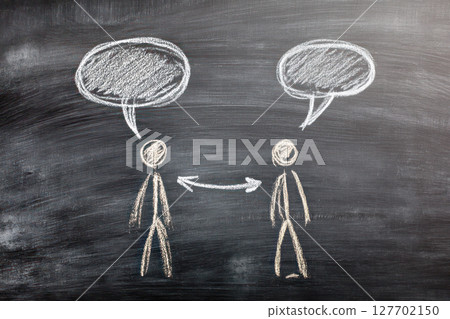 Two stick figures engaging in conversation with speech bubbles on a chalkboard background, illustrating communication and dialogue concepts in a creative way 127702150