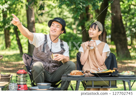 Friendly parents and children enjoying day camping, camping and barbecues at the park and campsite 127702745