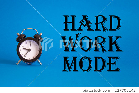 Hard Work Mode symbol. Concept word Hard Work Mode on Beautiful blue background with alarm clock. Business and Hard Work Mode concept. Copy space 127703142