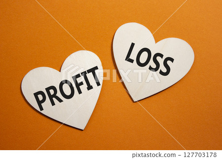 Profit or Loss symbol. Concept word Profit or Loss on wooden hearts. Beautiful orange background. Business and Profit or Loss concept. Copy space 127703178